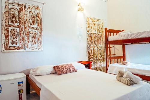 a room with two beds and a bunk bed at Vila Baiana Pousada in Itacaré