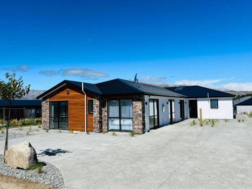 a house with a driveway in front of it at Stellar Apartment in Lake Tekapo