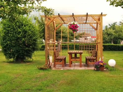 a wooden gazebo with a table and chairs in a yard at Residence Ortlerhof in Prato allo Stelvio
