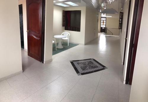 a hallway with a door and a rug on the floor at Hotel Vigua in Zipaquirá