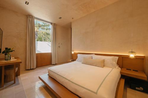 a bedroom with a large bed and a window at DECU DOWNTOWN in Mérida