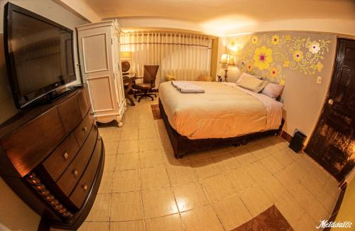 Habitación de hotel con cama y TV de pantalla plana. en Bull House en Urubamba