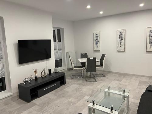 a living room with a tv and a table with chairs at Stunning 2-Room Penthouse with Lakeview W11 in Bucharest