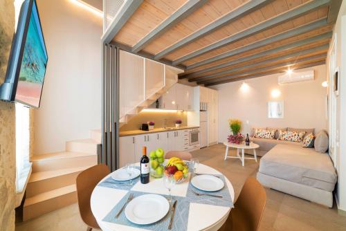 cocina y sala de estar con mesa y sillas en Pal Calma Suites en Rethymno