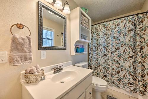 a bathroom with a sink and a toilet and a mirror at Pet-Friendly Shady Oaks Broken Bow Gem with Patio! in Broken Bow