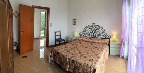 een slaapkamer met een groot bed met een smeedijzeren hoofdeinde bij Casa dei Glicini in Nardò