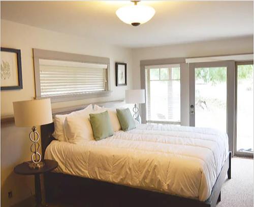 a bedroom with a large bed and a window at The Cottages on Salt Spring Island in Ganges