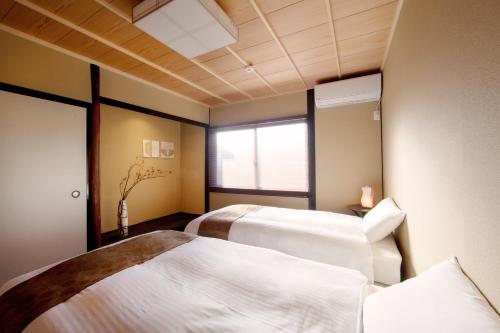um quarto com duas camas e uma janela em Rinn Tofukuji Kamogawa em Quioto