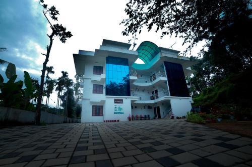 a white building with a large window on it at Bethel Service Villa, Mananthavady, Wayanad in Wayanad