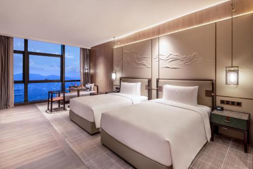 A bed or beds in a room at HUALUXE Hotels and Resorts Qingdao Licang, an IHG Hotel