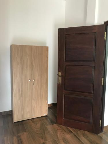 a room with a wooden cabinet next to a door at Om yoga Shala Beruwala in Beruwala