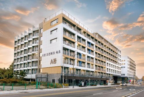 a large white building on the side of a street at Risen Ocean Park Hotel in Sokcho