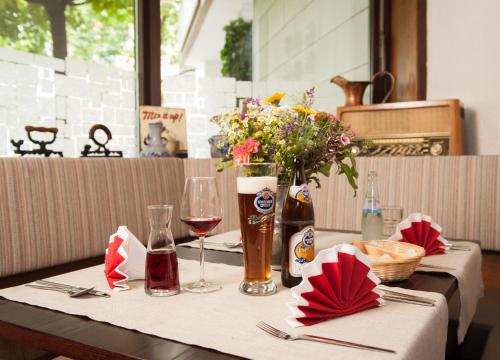 una mesa con una copa de vino y flores. en Stern Hotel Soller, en Ismaning