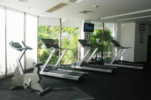 a gym with three tread machines in a room with windows at Pullman Sanya Yalong Bay Villas & Resort in Sanya