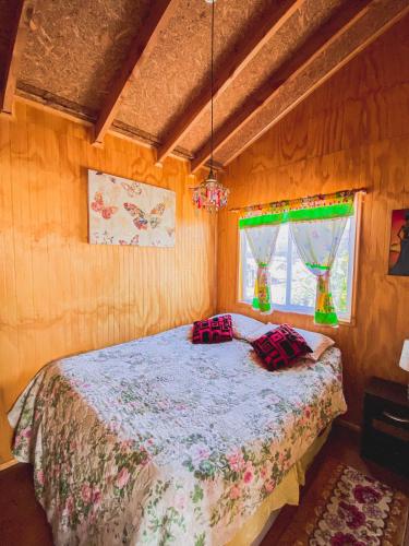 1 dormitorio con 1 cama con 2 almohadas en Cabañas Mi Escondite en Coihaique