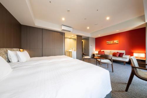a hotel room with a large bed and a living room at Tokyu Stay Sapporo in Sapporo