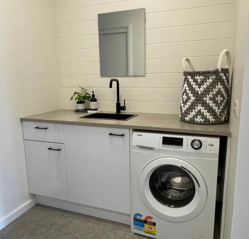 a kitchen with a washing machine and a sink at Kiama Palms on Terralong in Kiama