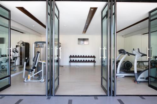 a gym with glass doors and exercise equipment at Season Five Hotel "SHA Certified" in Pattaya