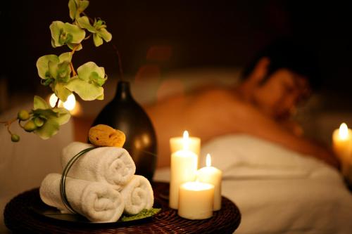a table with towels and candles and a person in bed at Pullman Sanya Yalong Bay Villas & Resort in Sanya