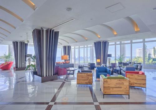 a lobby with blue chairs and tables and windows at Royal View Hotel Churaumi - Closest to Churaumi in Motobu