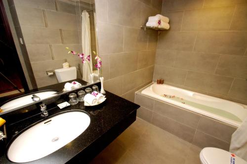a bathroom with a sink and a toilet and a tub at Asia Paradise Hotel in Nha Trang