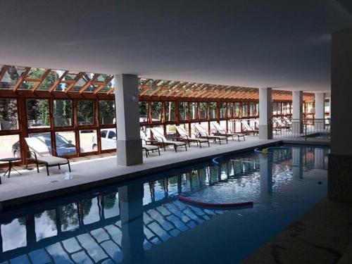 una piscina con sillas en un edificio en Vista Azul Suites, en Pedra Azul