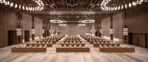 a lecture hall with rows of chairs and a stage at HUALUXE Hotels and Resorts Qingdao Licang in Qingdao
