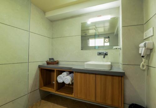a bathroom with a sink and a mirror at Gold Beach Villa in Daman