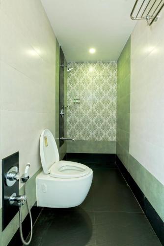 a bathroom with a toilet and a shower at Gold Beach Villa in Daman