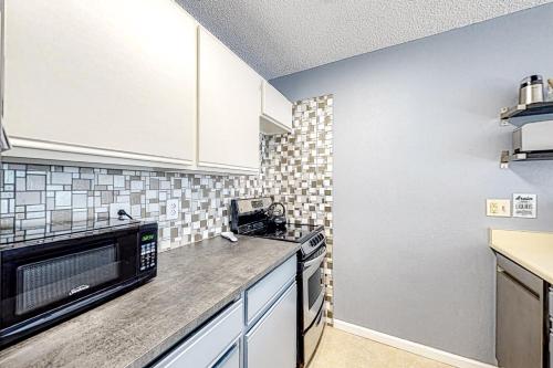 a kitchen with white cabinets and a microwave at Snowblaze Studio in Winter Park