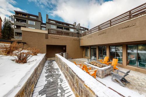 a building with orange tables and chairs in the snow at Snowblaze Studio in Winter Park
