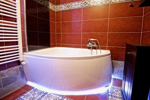 a bath tub with a faucet in a bathroom at Noclegi Styrnol & SPA in Zawoja