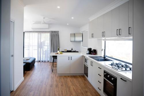 a kitchen with white cabinets and a counter top at Corowa Bindaree Holiday Park in Corowa