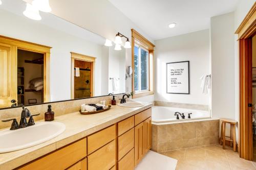 a bathroom with two sinks and a tub and a tubermott at Three Capes Bungalow in Oceanside