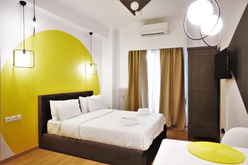 a hotel room with a bed and a yellow wall at GK Aria in Athens