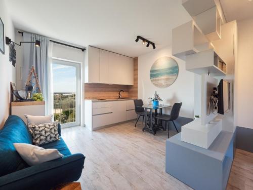 a living room with a blue couch and a kitchen at New apartment ViVaNo VAL with amazing view in Zambratija