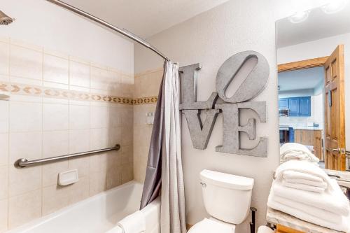 - une salle de bains pourvue de toilettes et d'une baignoire ainsi qu'un panneau qui se lit bien dans l'établissement Copper Valley 107, à Copper Mountain