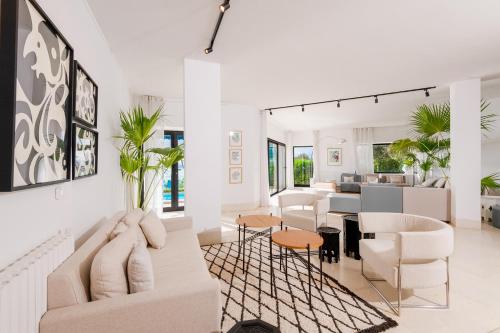 a living room with white furniture and a kitchen at La Demeure in Sidi Bou Saïd
