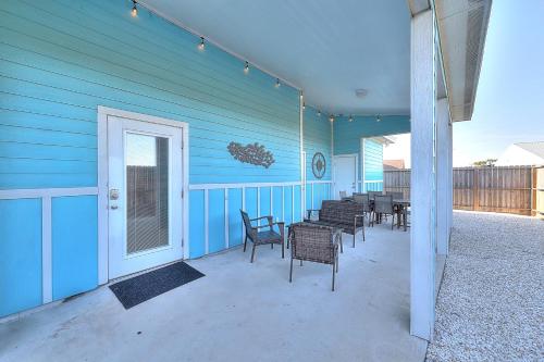 a blue house with chairs and tables on a patio at Love & Luck in Corpus Christi