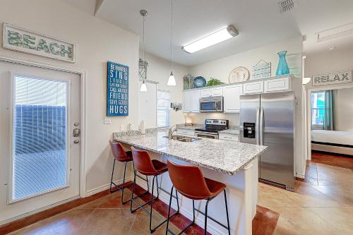 a kitchen with a island with bar stools at Love & Luck in Corpus Christi