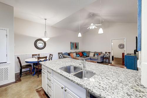a kitchen with a sink and a living room at Love & Luck in Corpus Christi