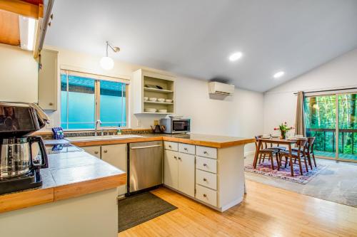 a kitchen with white cabinets and a table at Sugarpine Retreat in Bellingham