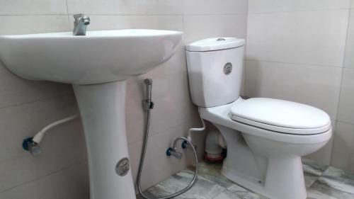 a bathroom with a white toilet and a sink at Flower Top Ella in Ella