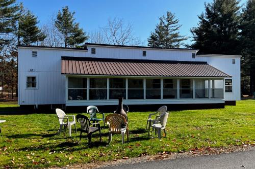 a table and chairs in front of a building at Riverbank's Pemi Cottage in Lincoln