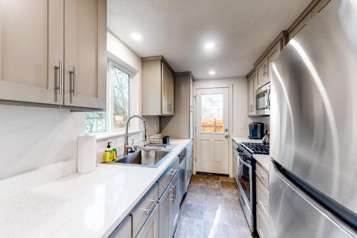 a white kitchen with a sink and a refrigerator at Pearl Place in Eugene
