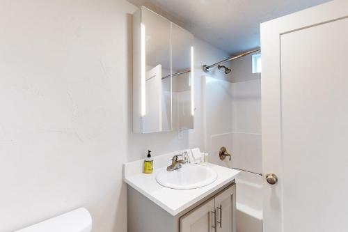 a white bathroom with a sink and a mirror at Pearl Place in Eugene