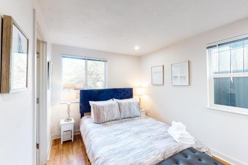 a bedroom with a bed with a blue headboard and a window at Pearl Place in Eugene
