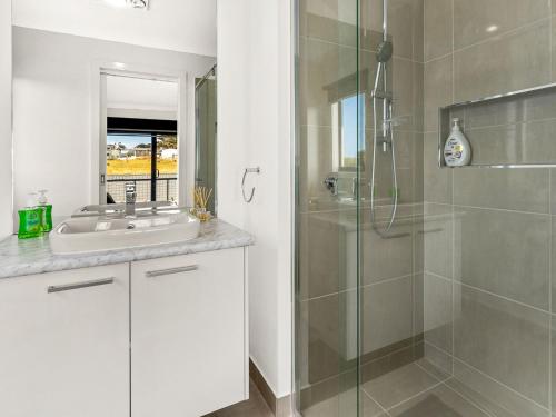 een badkamer met een wastafel en een glazen douche bij Castaway Views in San Remo