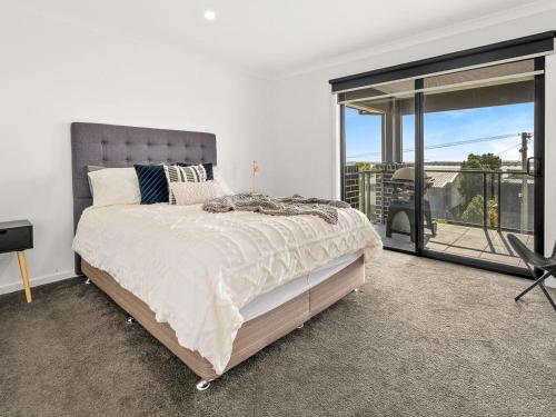 een slaapkamer met een bed en een groot raam bij Castaway Views in San Remo