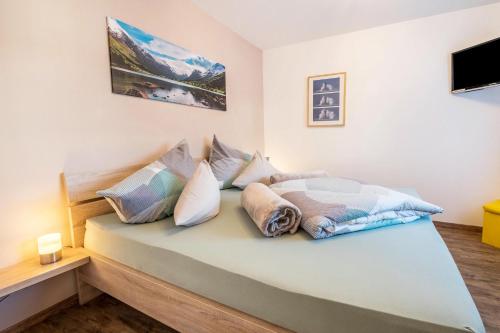 sypialnia z łóżkiem i poduszkami w obiekcie Wieseneck I - Apartment in Fügen w mieście Fügen
